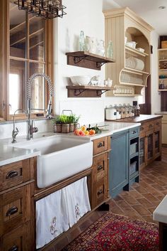 a kitchen filled with lots of wooden cabinets and white counter tops next to a sink