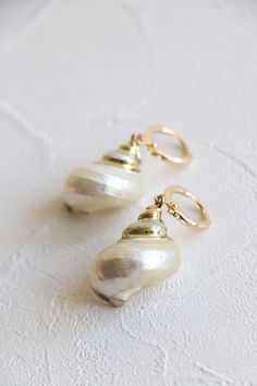 Natural sea shell gold hoop earrings in 18k gold plated.  Earrings hoop size: 12mm dia  Shell size: about 25-30mm Metal component: 18k gold plated brass base This listing is for a pair of earrings. ﹎﹎﹎﹎﹎﹎﹎﹎﹎﹎﹎﹎﹎﹎﹎﹎﹎﹎﹎﹎﹎﹎ ▲ Care instruction:  Please remove it before bathing or swimming.  Avoid your jewelry touching chemical such as hairsprays or perfumes.  Using soft cloth to clean your jewelry every time after wearing it, and store it in a dry and cool place. ▲ Gift packaging:  All products will Gold 14k Gold Filled Earrings For Beach, Gold Shell-shaped Hoop Earrings For Beach, Gold Shell Earrings For Summer, Pearl Charm Shell Earrings For Beach, Gold Shell-shaped Hoop Earrings, Gold Shell-shaped Hoop Earrings For Pierced Ears, Gold Shell With Matching Earrings, Gold Pearl Drop Earrings With Ocean-inspired Style, Elegant Shell-shaped Gold Hoop Earrings