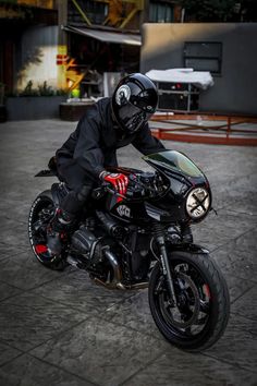 a man riding on the back of a black motorcycle