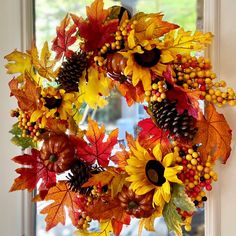 a wreath with autumn leaves and pine cones