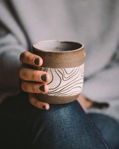 a woman's hand holding a coffee cup