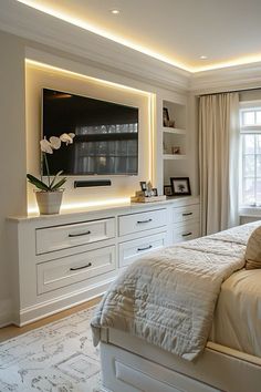 a bedroom with white furniture and a flat screen tv mounted on the wall above it