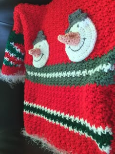 a red and green christmas sweater with snowmen on it