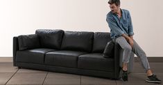 a man sitting on top of a black couch