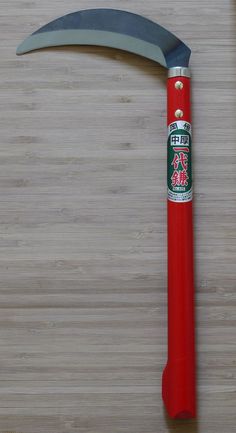 a red handled knife on top of a wooden table