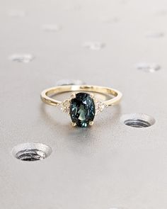 a blue and white diamond ring sitting on top of a table