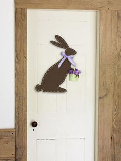 a door decorated with a bunny holding a basket of flowers in it's hand