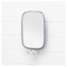 a bathroom mirror mounted to the side of a white wall next to a tiled wall