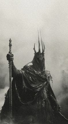 a black and white photo of a man with horns on his head holding a staff