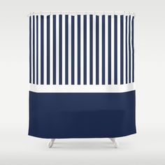 a blue and white shower curtain with vertical stripes on the bottom, in front of a gray background