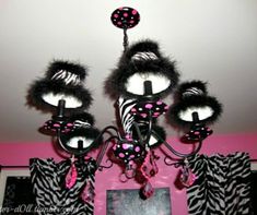 a chandelier hanging from the ceiling in a room with pink walls and zebra print curtains