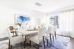 a dining room table with white chairs around it