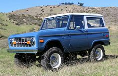 an old blue truck parked in a field