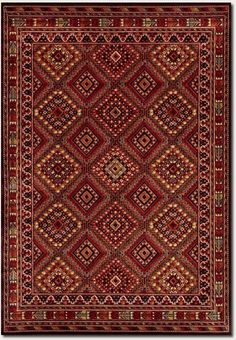 a red rug with an intricate design on the bottom and sides, in different colors