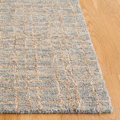 a blue and beige rug on the floor with wood floors in the background at home