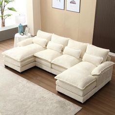 a large white sectional sofa sitting on top of a hard wood floor