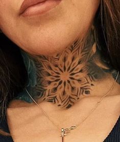 a woman with tattoos on her neck is looking at the camera while wearing a necklace