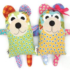 two stuffed animals are sitting next to each other on a white background with polka dots