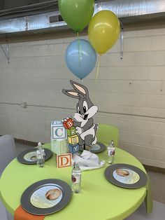 a table with plates and balloons on it