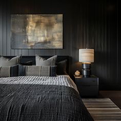 a bedroom with black walls and striped bedding