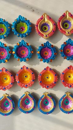 there are many different colored items on the table, including earrings and brooches