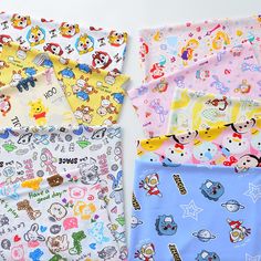 four different types of baby swaddles laid out on a white surface with cartoon characters all over them