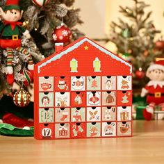 a wooden calendar sitting on top of a table next to a christmas tree and elf figurines