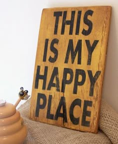 a sign that says this is my happy place next to a vase and potted plant