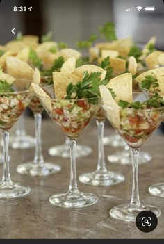 several martini glasses filled with different types of food and garnished with cilantro