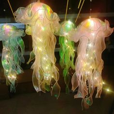 three jellyfish lights hanging from strings in the shape of sea creatures with green, yellow and white lights