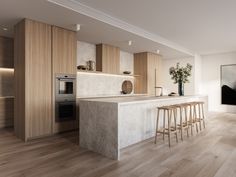 a kitchen with an island and stools in front of the counter top, along with wooden flooring