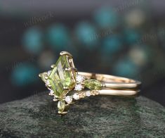 a close up view of an engagement ring with green and white stones