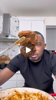 a man is holding up two large donuts in front of his face