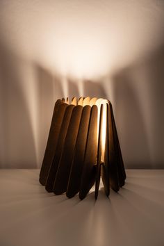 a lamp that is sitting on top of a table with light coming from behind it