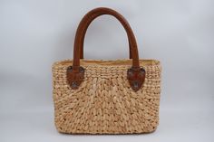 a straw bag with leather handles on a white background