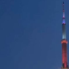 an airplane is flying in the sky over a building