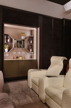 a living room filled with white furniture next to a wall mounted wine bottle dispenser