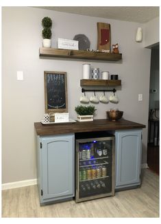 a small refrigerator in the corner of a room with shelves on the wall above it