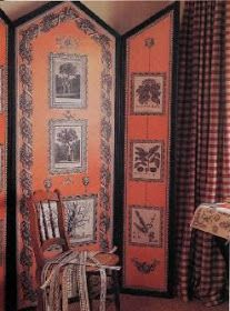 an orange room with pictures on the wall and chairs in front of it, along with curtains