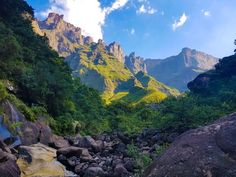 the mountains are covered in green vegetation and rocks