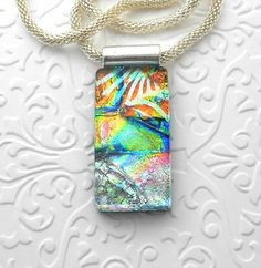 a necklace with an image of a bird in the sky on it's side