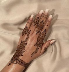 a woman's hand with henna tattoos on it