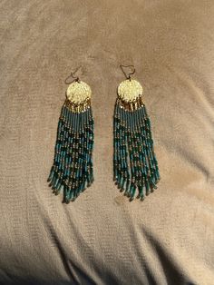 It's fun to start making a pair of earrings by first looking at the (semi) precious stones that I have in my treasure chest 💎. In this case I found two strands of kyanite. The kyanite has a very beautiful grayish blue/green color and has a calming effect. It has exactly the color of Miyuki's 'transparent eucalyptus' seed beads. My choice to start working with kyanite was therefore quickly made. I combined the calm colors of the kyanite and eucalyptus with a touch of gold, 'peacock rainbow' and Adjustable Round Beaded Earrings For Festive Occasions, Nickel Free Round Beads Earrings For Festival, Nickel Free Beaded Earrings For Festival, Festival Dangle Jewelry With Gold Beads, Artisan Earrings With Dangling Beads, Beaded Brass Jewelry, Artisan Drop Earrings With Beaded Fringe, Artisan Beaded Fringe Earrings For Jewelry Making, Bohemian Dangle Earrings With Gold Beads