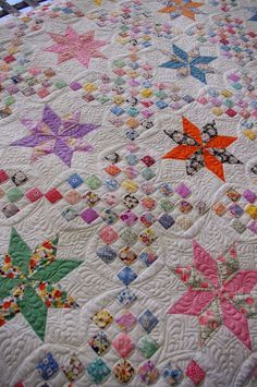 a quilted bed with many different colored stars on it