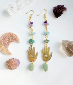 Hamsa Hand Crystal crystal dangle gold plated earrings :)  Spiritual hamsa hands represent Power, Strength & Protection. Each crystal also has its own unique purpose.  ⭐️Green Aventurine symbolizes strength, happiness & courage ⭐️Aquamarine has a shielding effect on your energy field,  stone of courage and preparedness. ⭐️Amethyst for protection, cleansing , peace ⭐️Citrine is associated with positivity and optimism ⭐️Turquoise jasper  can aid the throat chakra, dream recall and enables the understanding of dreams All crystals are cleansed and charged before shipping :) ⭐️CARING FOR YOUR JEWELLERY Gold Plated Jewellery:  To care for your jewellery please avoid coming into contact with water, perfume, lotions, hairsprays and detergents as this may cause your jewellery to tarnish. Dream Recall, Water Perfume, Gold Plated Jewellery, The Throat Chakra, All Crystals, Cats Eye, Jewellery Gold, Energy Field, Throat Chakra