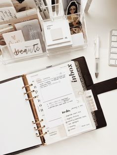 an open planner sitting on top of a desk next to a keyboard