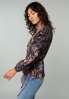 An ultra-flattering wrap top designed in a grey and dusty blue floral print. FINAL SALE Floral print Relaxed fit Voluminous long sleeve Elastic wrist cuff V-neckline Wrap front Adjustable side tie closure Bohemian wrap top Fall's flirtiest top has arrived! Designed in pretty florals, this flattering wrap top features voluminous long sleeves, a plunging v-neckline, and an adjustable side tie closure. We love to style this effortless blouse for date nights with denim and a strappy heel. Model is 5 Floral Wrap Top, Bohemian Wrap, Floral Wraps, Blue Floral Print, Wrist Cuffs, Wrap Top, Dusty Blue, Blue Floral, Final Sale