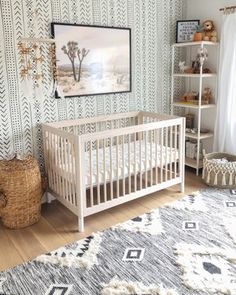 a baby's room with a white crib in the corner and a rug on the floor