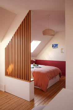 an attic bedroom with wooden slats on the wall and hardwood flooring, along with a bed