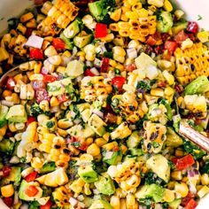 a bowl filled with corn salad and a spoon